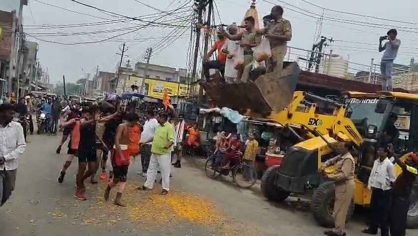 Kasganj: सिढपुरा मे कांवड़ियों का अनोखे अंदाज मे स्वागत, बुलडोजर पर चढ़ पुलिस-प्रशासन ने बरसाए फूल,बांटे फल